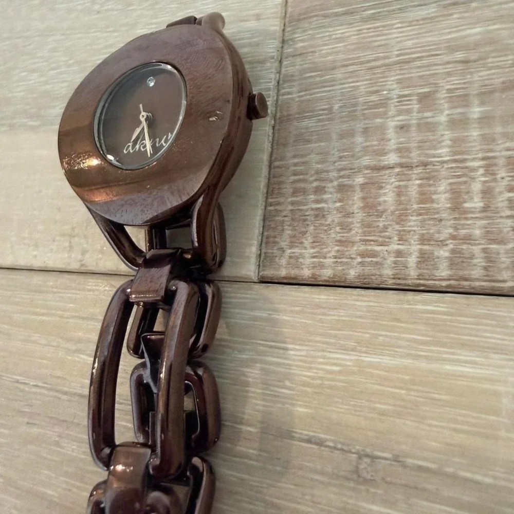 brown DKNY wristwatch featuring a distinct oval case and chain-link bracelet